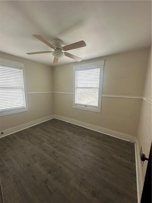 unfurnished room featuring dark wood-type flooring, ceiling fan, and a wealth of natural light