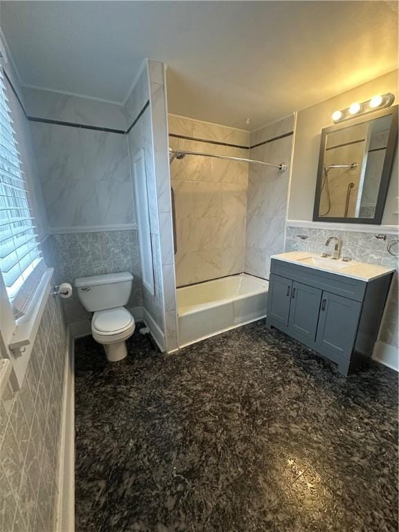 full bathroom featuring tile walls, vanity, toilet, and tiled shower / bath