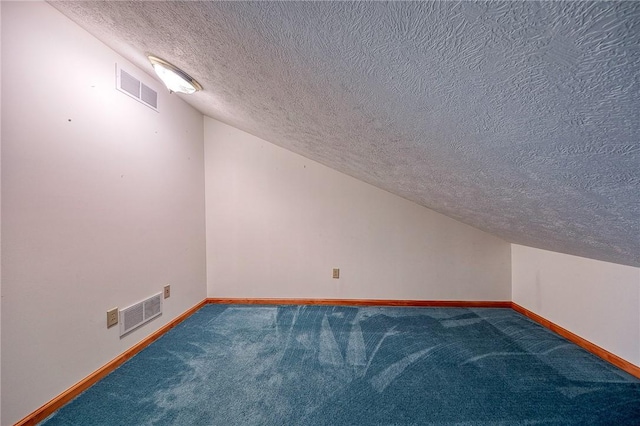 bonus room with lofted ceiling, a textured ceiling, and carpet flooring