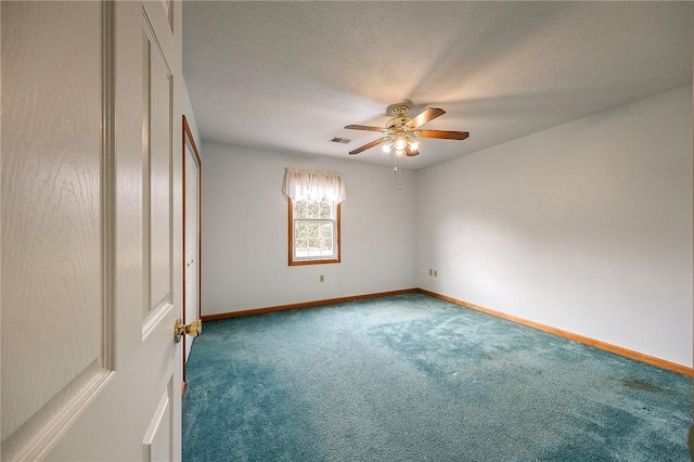 spare room featuring ceiling fan, carpet, and a textured ceiling