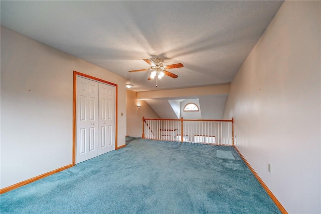 additional living space with a textured ceiling, ceiling fan, and carpet