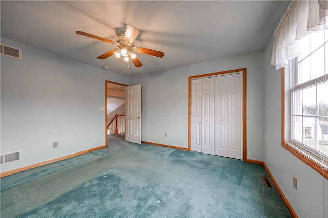 unfurnished bedroom featuring ceiling fan, carpet flooring, and a closet