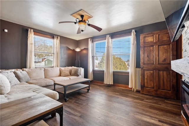 living room featuring ceiling fan and dark hardwood / wood-style flooring