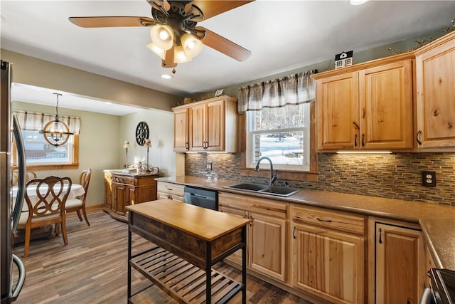 kitchen featuring pendant lighting, sink, dark wood-type flooring, and dishwasher