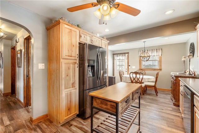 kitchen with light brown cabinets, light wood-type flooring, pendant lighting, ceiling fan, and stainless steel appliances