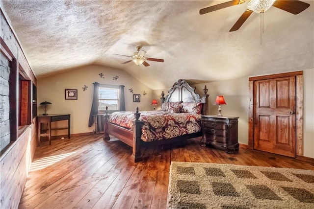 bedroom with lofted ceiling, dark hardwood / wood-style floors, radiator heating unit, and a textured ceiling