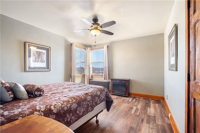 bedroom with ceiling fan, radiator, and hardwood / wood-style floors