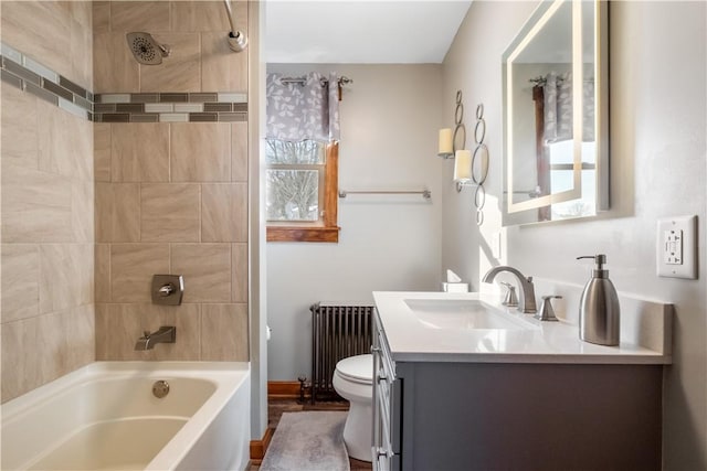 full bathroom featuring vanity, radiator, toilet, and tiled shower / bath