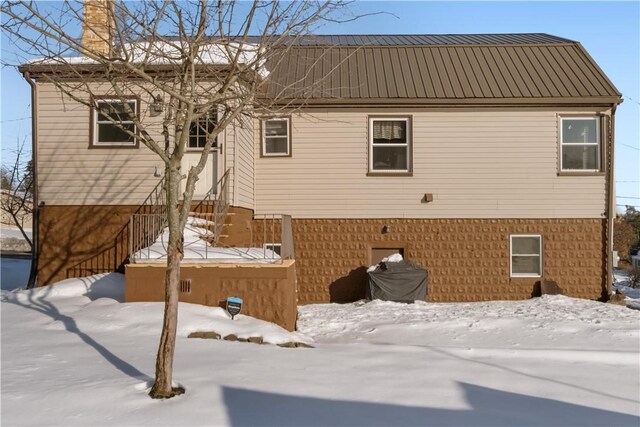 view of snow covered back of property