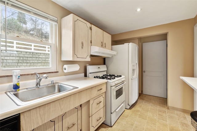 kitchen featuring sink, light brown cabinetry, and white gas stove