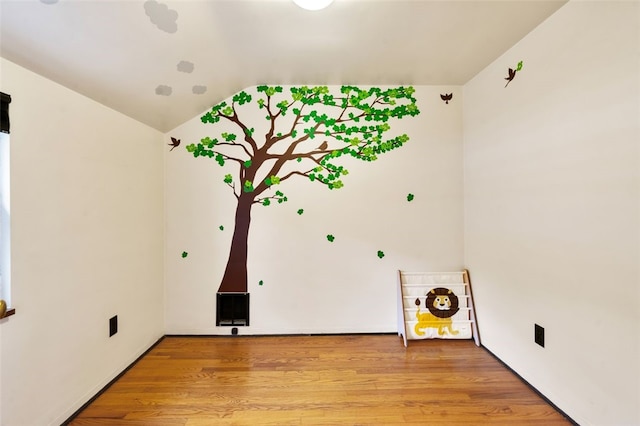 empty room with lofted ceiling and light hardwood / wood-style flooring