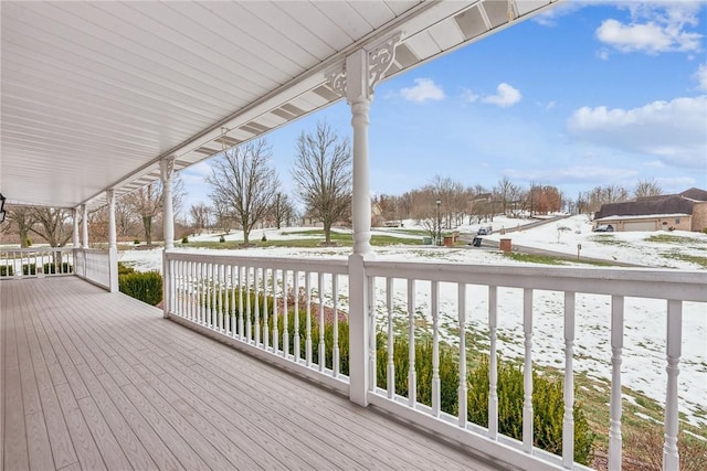 snow covered deck with a porch