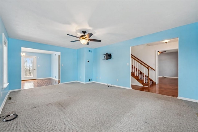 unfurnished living room with ceiling fan and carpet