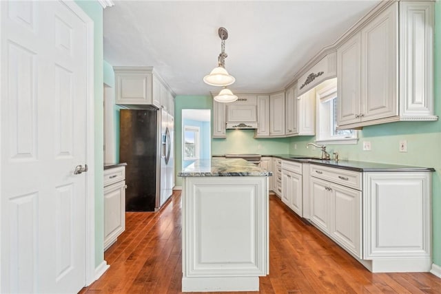 kitchen with white cabinetry, pendant lighting, a kitchen island, and stainless steel refrigerator with ice dispenser