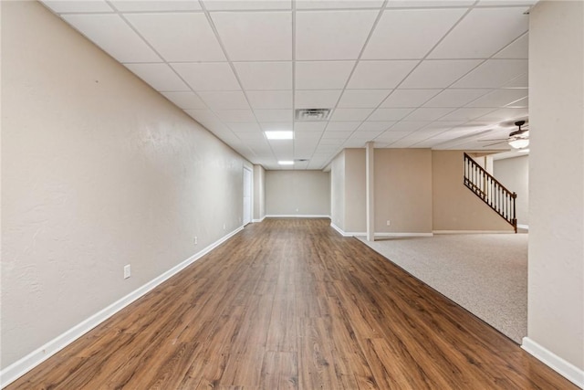 basement featuring hardwood / wood-style flooring, a paneled ceiling, and ceiling fan