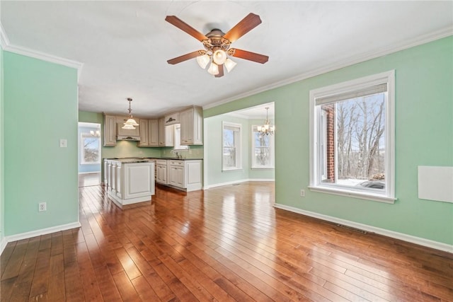 unfurnished living room with wood-type flooring, sink, ceiling fan with notable chandelier, and crown molding