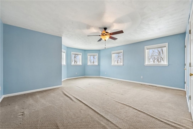 carpeted spare room featuring a textured ceiling and ceiling fan