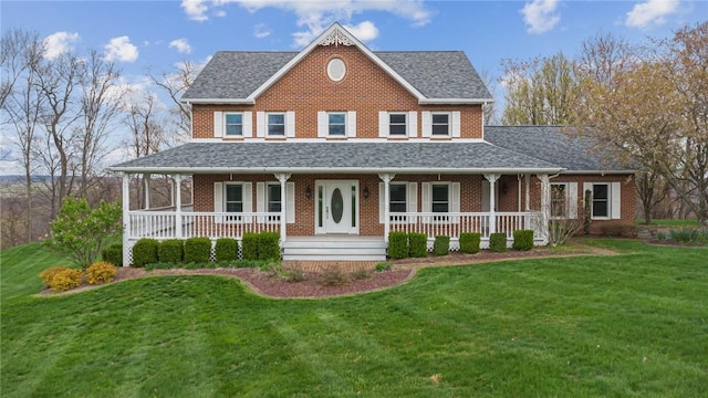 country-style home featuring brick siding, a porch, and a front yard