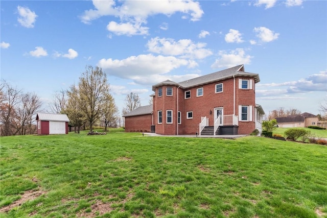 rear view of house featuring brick siding, a yard, and a detached garage