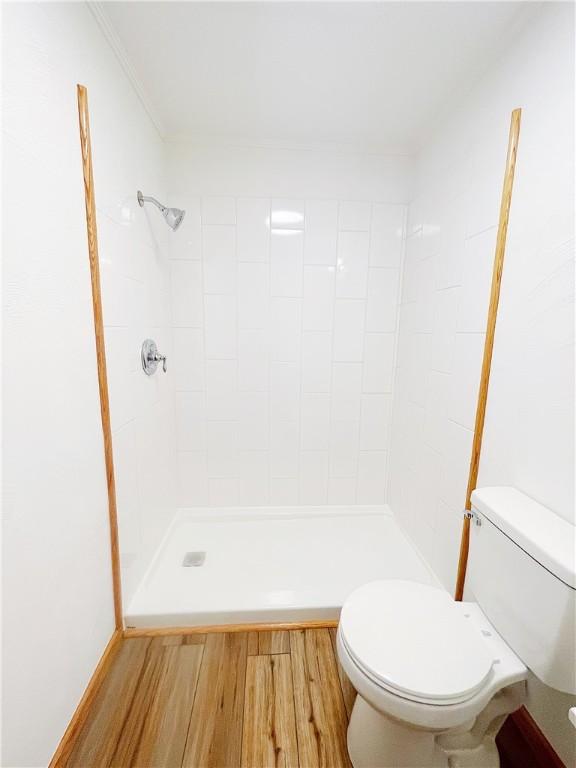 185 Holly Ln, Somerset Twp, PA 15501 - bathroom with toilet, tiled shower, and wood finished floors