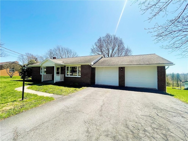 185 Holly Ln, Somerset Twp, PA 15501 - ranch-style home featuring a garage, brick siding, aphalt driveway, and a front lawn