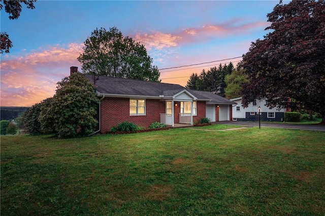 185 Holly Ln, Somerset Twp, PA 15501 - ranch-style home featuring driveway, a chimney, an attached garage, a front yard, and brick siding