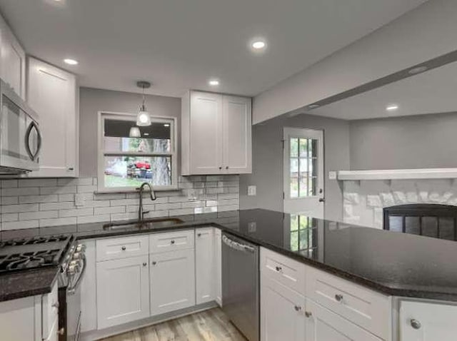 kitchen with stainless steel appliances, sink, and white cabinets