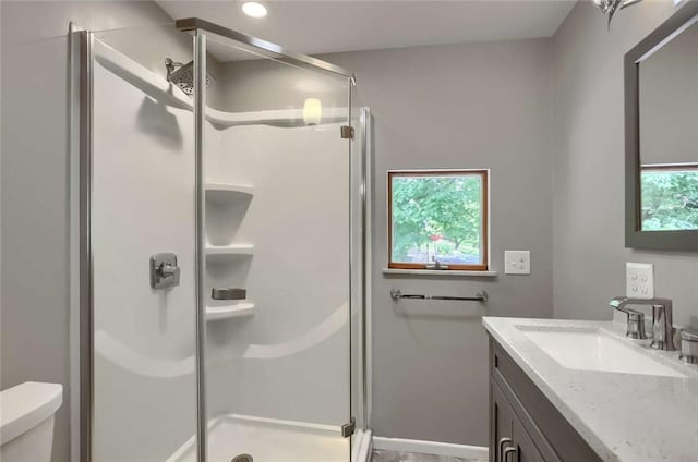 bathroom with vanity, an enclosed shower, and toilet