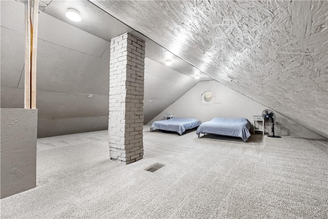 carpeted bedroom with vaulted ceiling and ornate columns