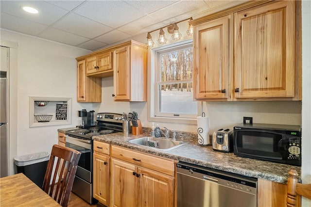 kitchen with sink, a paneled ceiling, and appliances with stainless steel finishes