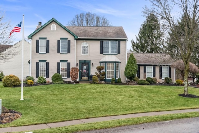 colonial inspired home with a front lawn