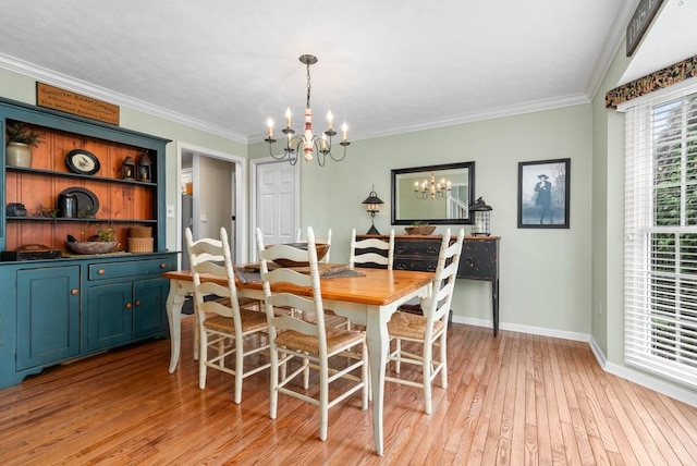 dining area with ornamental molding, light hardwood / wood-style flooring, and a notable chandelier