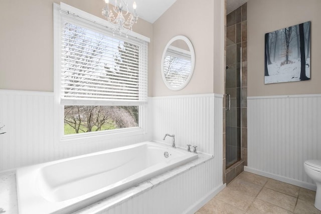 bathroom featuring lofted ceiling, tile patterned floors, toilet, an inviting chandelier, and separate shower and tub