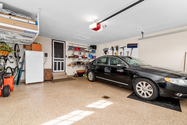 garage with white refrigerator and a garage door opener