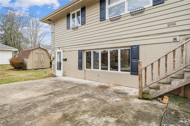 back of house with a patio and a storage shed