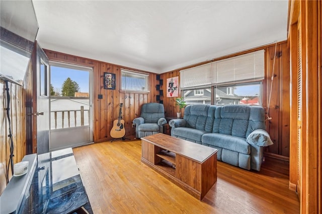 living room featuring wooden walls and light hardwood / wood-style floors