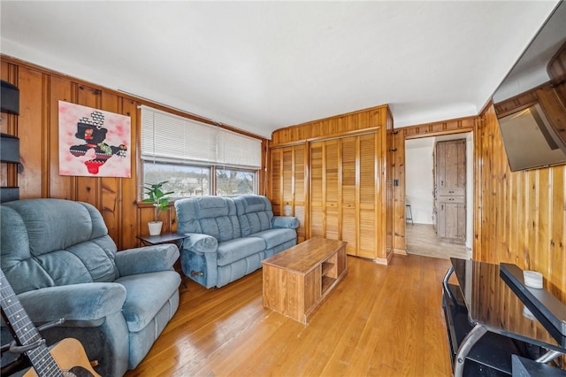 living room with wooden walls and light hardwood / wood-style flooring