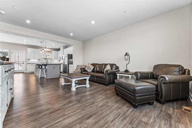 living room featuring dark hardwood / wood-style floors and sink