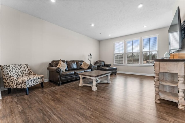 living room with a healthy amount of sunlight, dark hardwood / wood-style floors, and a textured ceiling