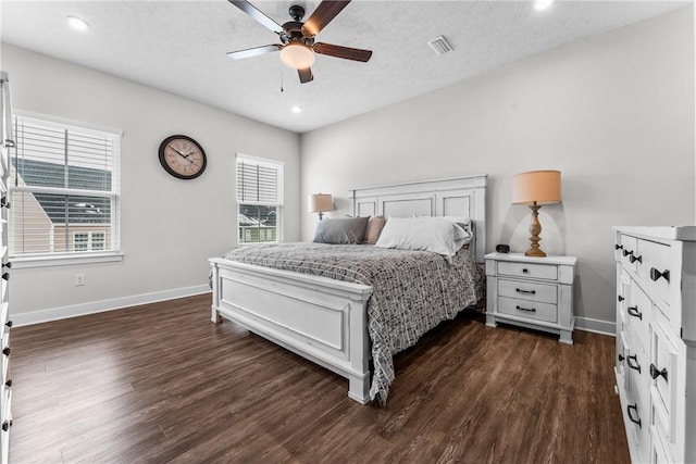 bedroom with ceiling fan, dark hardwood / wood-style floors, and a textured ceiling