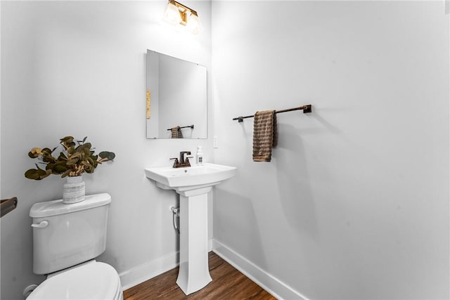 bathroom featuring wood-type flooring and toilet