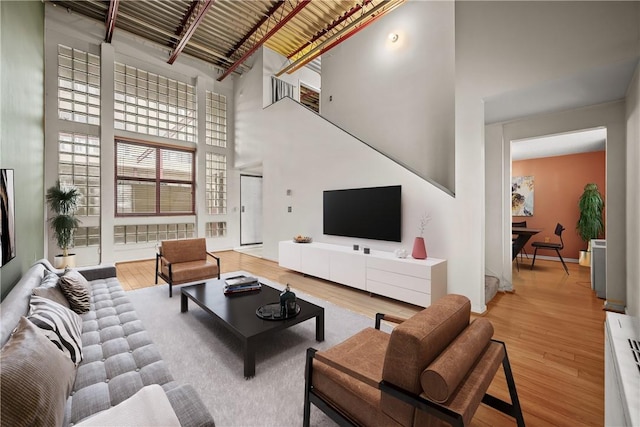 living room with a towering ceiling and light hardwood / wood-style floors