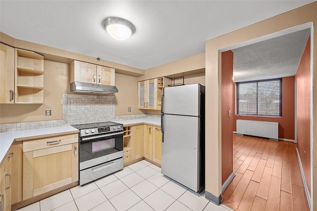 kitchen with light brown cabinetry, appliances with stainless steel finishes, radiator, light hardwood / wood-style floors, and backsplash