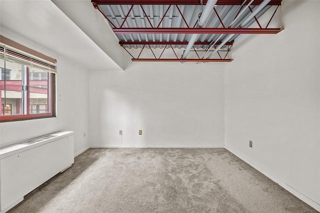 carpeted spare room featuring radiator