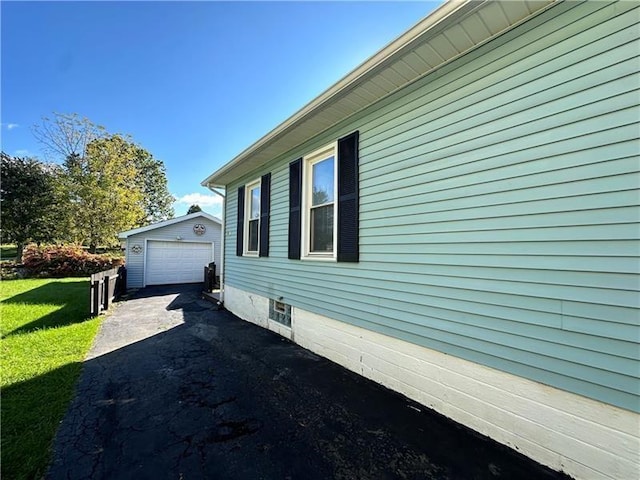 view of side of property featuring a garage, an outdoor structure, and a lawn