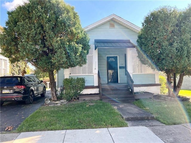 bungalow-style home with a front yard