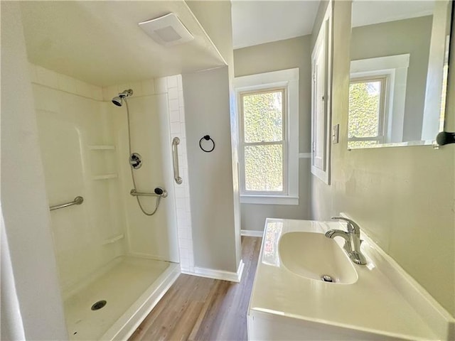 bathroom with sink, plenty of natural light, hardwood / wood-style floors, and a shower