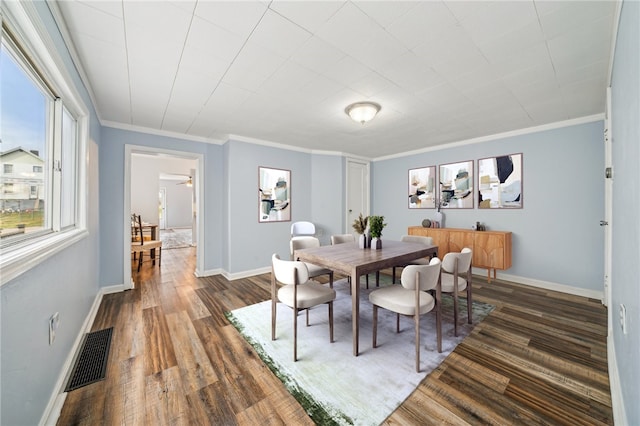 dining space with ornamental molding and dark hardwood / wood-style floors