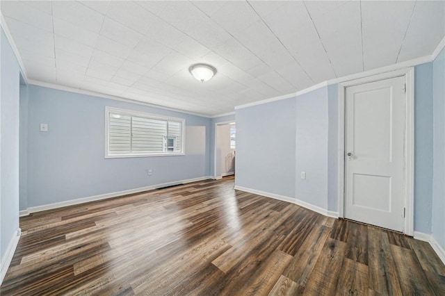 spare room with ornamental molding and dark wood-type flooring