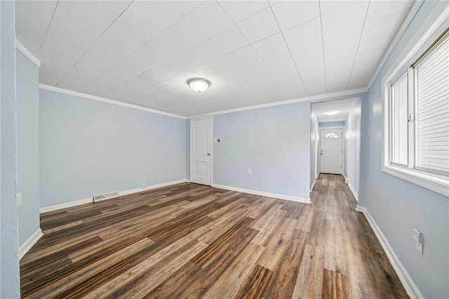 empty room with crown molding and dark hardwood / wood-style floors